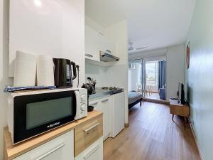a kitchen with a microwave and a tv on a counter at studio cosy - champ fleuri in Sainte-Clotilde +3 photos