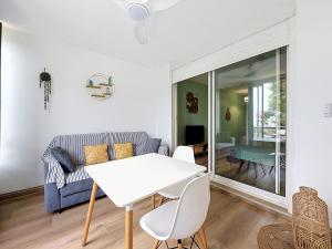 a living room with a white table and a couch at studio cosy - champ fleuri in Sainte-Clotilde