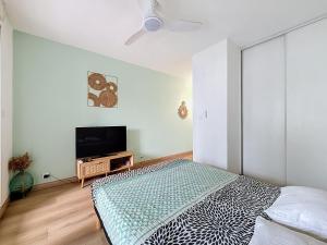 a bedroom with a bed and a flat screen tv at studio cosy - champ fleuri in Sainte-Clotilde