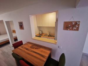 a dining room with a table and a kitchen at Apartments Škrobot in Senj