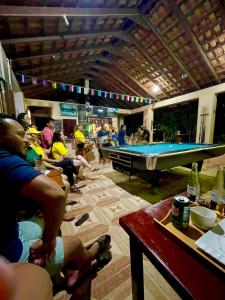 a group of people sitting in a room with a pool table at The Mountainstream Lodge in Lethem