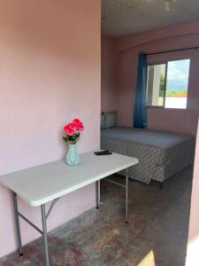 a room with a table with a vase of flowers on it at Hotel Atlántida in La Ceiba