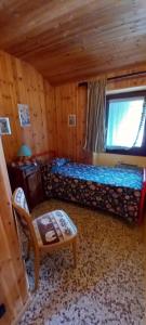 a bedroom with a bed and a chair in a room at La gerbe d'or in Saint Nicolas