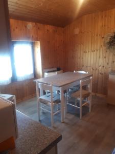 a table and chairs in a room with wooden walls at La gerbe d'or in Saint Nicolas