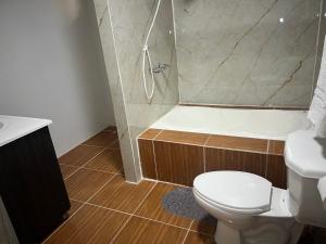 a bathroom with a shower and a toilet and a sink at Hotel Atlántida in La Ceiba