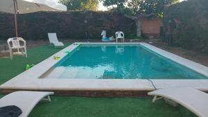 a woman is sitting next to a swimming pool at Villa Antonina 2 in Crecchio