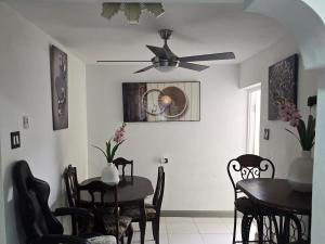 a dining room with two tables and a ceiling fan at BW Hideaway in Portmore