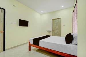 a bedroom with a bed and a tv on a wall at SPOT ON Deepla Grand in Warangal