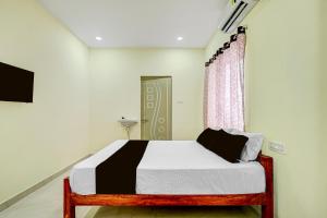 a bedroom with a bed and a window at SPOT ON Deepla Grand in Warangal