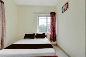 a bed in a room with a window at SPOT ON Deepla Grand in Warangal +46 photos