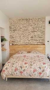 a bedroom with a bed with a stone wall at studio douillet en centre bourg in La Plaine-sur-Mer