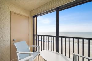 a room with a balcony with a view of the beach at Luxury Oceanfront Penthouse Condo in Clearwater Beach