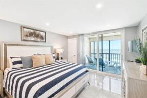 a bedroom with a bed and a balcony at Luxury Oceanfront Penthouse Condo in Clearwater Beach