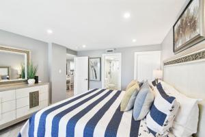 a bedroom with a blue and white striped bed at Luxury Oceanfront Penthouse Condo in Clearwater Beach