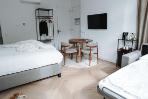 a bedroom with two beds and a table and chairs at Residence Paradis in Zandvoort