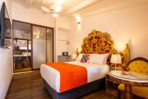a bedroom with a large bed and a table at Hotel Monasterio del Inka Cusco in Cusco