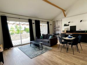 a living room with a couch and a table at Paradisier, clim, grande terrasse, balneo, Parc des Oiseaux in Villars-les-Dombes