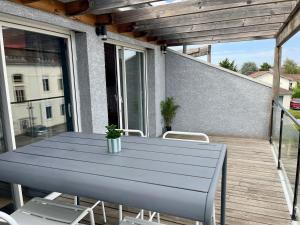 a blue table and chairs on a balcony at Paradisier, clim, grande terrasse, balneo, Parc des Oiseaux in Villars-les-Dombes