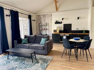 a living room with a couch and a table at Paradisier, clim, grande terrasse, balneo, Parc des Oiseaux in Villars-les-Dombes