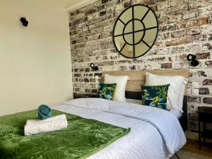 a bedroom with a brick wall and a large bed at Paradisier, clim, grande terrasse, balneo, Parc des Oiseaux in Villars-les-Dombes