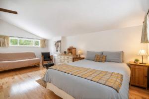 a bedroom with a large bed and a couch at Chalet Chic et Spa - St-Come in Saint Come