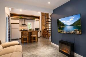 a living room with a tv hanging on a wall at Chalet Chic et Spa - St-Come in Saint Come +18 photos