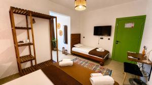 a small room with a bed and a green door at Mlinova Küçükköy in Ayvalık