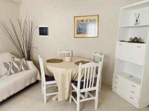 a white dining room with a table and chairs at Palaiopolis house in Kanoni