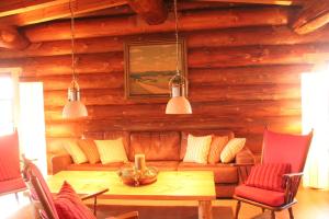 ein Wohnzimmer mit Sofa und Tisch in der Unterkunft Dein Blockhaus in Gollenberg