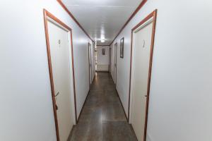 a hallway with white doors and a tile floor at Nikos II Adventure in Puerto Natales
