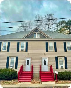 a house with red benches in front of it at Charming Cozy Getaway in Oneonta