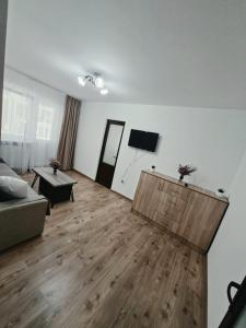 a living room with a couch and a wooden floor at Codruta Home in Râmnicu Vâlcea