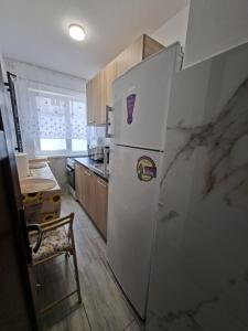 a kitchen with a refrigerator with magnets on it at Codruta Home in Râmnicu Vâlcea