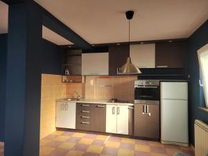 a kitchen with white cabinets and a refrigerator at The VIEW in Belgrade
