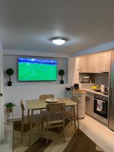 a kitchen with a table and a television on the wall at Kurti Home in Agia Triada