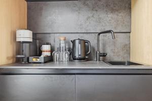 a kitchen counter with a sink and a mixer at The Maida Hotel in London +16 photos