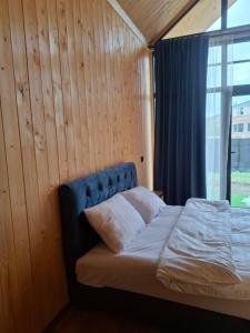 a bed in a room with a wooden wall at AnArt rezort in Vanadzor +7 photos