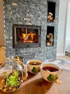 a table with bowls of soup and a fireplace at Mount House Mavrovo in Mavrovo