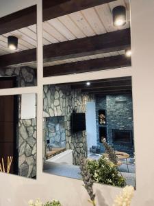 a room with a stone wall with a mirror at Mount House Mavrovo in Mavrovo