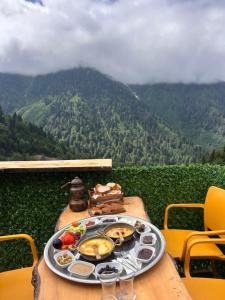 a tray of food on a table with a view of a mountain at Peak ayder bungalow in Ayder Yaylasi