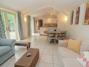 a living room with a couch and a table at Meadow Lodge in Cirencester