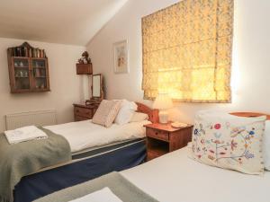 a bedroom with two beds and a window at Meadow Lodge in Cirencester