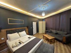 a bedroom with a large bed and a couch at Riwaner Hotel in Avcılar