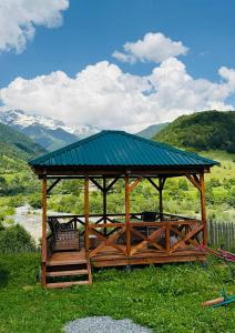 a wooden gazebo with a bench in a field at Mountain Shadow Cottage in Racha in Ghebi +47 photos
