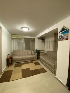 a living room with two couches and a rug at Kurti Home in Agia Triada