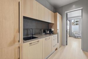 a kitchen with wooden cabinets and a sink at The Maida Hotel in London