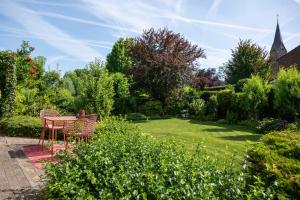 a patio with a table and chairs in a garden at Bij Corine, bed en zorg in Altforst