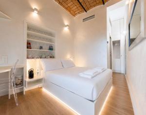 a white bedroom with a large white bed with lights at Ponte Milvio Roma Elegance Room & Private Parking in Rome