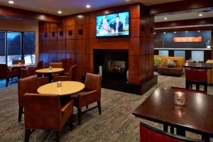 a restaurant with tables and a fireplace and a tv at Courtyard by Marriott Bloomington Mall of America in Bloomington