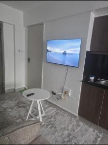 a room with a table and a tv on a wall at Luna Homes at Tsavo Sunset, Kiambu Road in Kiambu